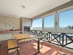 a dining room with a table and large windows at Summer Place in Knysna