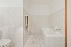 a white bathroom with a tub and a toilet at Summer Place in Knysna +9 photos