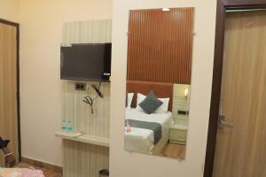 a hotel room with a bed and a mirror at The Amritsar View near Golden temple in Amritsar