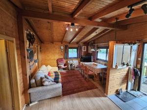 a living room with a couch and a table at Ferienhaus Waldgefluester in Nausis +22 photos