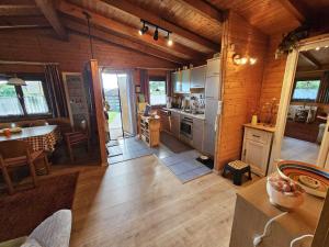a kitchen and dining room of a log cabin at Ferienhaus Waldgefluester in Nausis