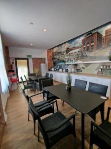 a restaurant with tables and chairs and a painting on the wall at New Adler Bed & Breakfast in Łódź