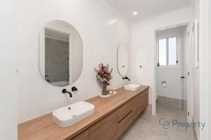 a white bathroom with a sink and a mirror at 'Laguna Haus' in Walker Flat +32 photos