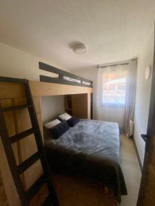 a bedroom with a bunk bed and a ladder at Le Cocon des Airelles - Meublé de tourisme 3 étoiles au pied des pistes avec garage in Montgenèvre +4 photos