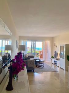 ein Wohnzimmer mit einer Couch und einem Tisch mit Blumen in der Unterkunft Los Granados de la Duquesa in San Luis de Sabinillas
