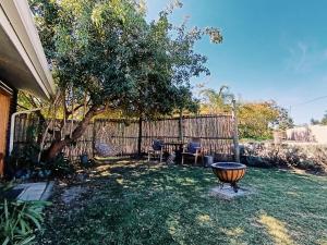 a yard with a fence and a table and chairs at Fire Fly Cabin in Knysna