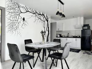 a dining room table with chairs and a tree mural at Lemberg Apart З червня басейн з підігрівом 10 на 5 метрів in Slavske