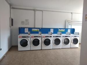 a laundry room with four washing machines in it at Enebrales Home in Punta Umbría