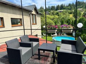 Un patio con sillas y una mesa y una piscina. en Lemberg Apart, en Slavske