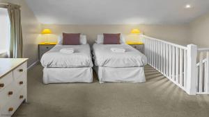 a bedroom with two beds and a staircase at Whitedown in Alton