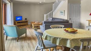 a living room with a table with a bowl of fruit on it at Whitedown in Alton +20 photos
