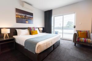 卧龙岗Coniston Hotel Wollongong的一间带大床和大窗户的卧室