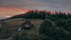 a small house on top of a hill with a car at Dream Catcher House - dom do wynajęcia w górach in Limanowa