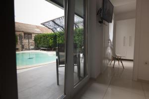 Una habitación con una puerta corrediza de vidrio que conduce a una piscina. en Basic Mansion Mandalina, en Šibenik