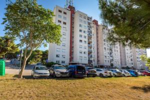 a large building with a lot of cars parked in front at Skyline Apartment in Veruda +25 photos