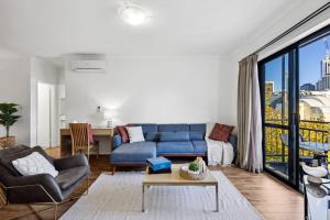 a living room with a blue couch and a table at Perth Prime Located 2BDR 1PRK in Perth
