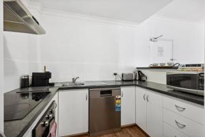 a kitchen with white cabinets and a stainless steel dishwasher at Perth Prime Located 2BDR 1PRK in Perth
