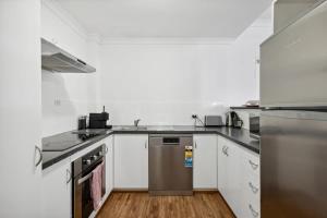 a kitchen with white cabinets and a stainless steel dishwasher at Perth Prime Located 2BDR 1PRK in Perth +21 photos