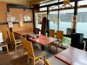 高槻市Takatsuki W and M Hotel的餐厅设有木桌、椅子和窗户