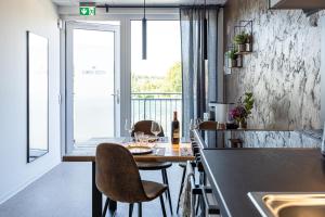 a kitchen with a table with chairs and a counter top at Hygge Homes - Cube Apartment in Borstel