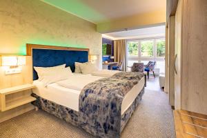 a hotel room with a large bed and a desk at Waldhotel Ehrental in Schmalkalden