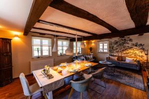 a dining room and living room with a table and chairs at Maison 1775 Ferien im historischen Bauernhaus mit Sauna, Wissembourg, Elsass in Ingolsheim