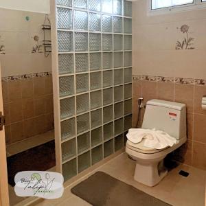 a bathroom with a toilet and a glass block wall at Bann Tulip Khaoyai in Mu Si +12 photos