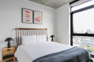 Un dormitorio con una gran cama blanca y una ventana. en Blueground West Loop gym pet area wd gym CHI-1098, en Chicago 34 fotos más