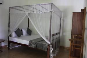 a bed with a canopy in a room at Sun and Surf Rest in Ahangama +68 photos