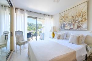 ein weißes Schlafzimmer mit Bett und Balkon in der Unterkunft Cannes Center Sea and Sky in Cannes + 29 Fotos