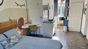 a bedroom with a bed and a kitchen with a sink at Le Pavillon Rennais - Garden Cottage in Rennes