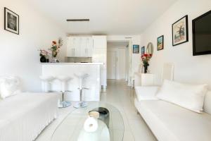 ein weißes Wohnzimmer mit einem weißen Sofa und einem Tisch in der Unterkunft Cannes Center Sea and Sky in Cannes