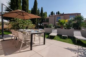 a patio with a table and chairs and an umbrella at AdeLis Residence by Locap Group in Portorož