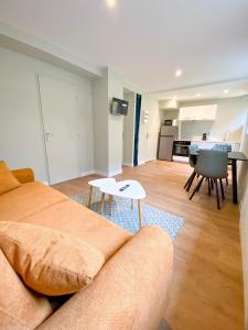 a living room with a couch and a table at L'Octopus - Appartement 2 adultes 2 enfants Jardin, proche centre et Plage in Le Portel +7 photos
