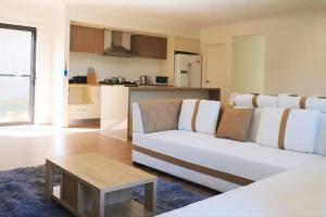 Una sala de estar con un sofá blanco y una mesa. en Kellyville Spacious Modern House Park&Lake, en Kellyville