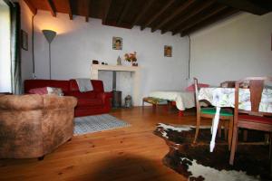 a living room with a red couch and a fireplace at Studio Les Pourettes in Feusines