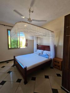 a bedroom with a bed with a canopy at Shanzu Mombasa One Bedroom & Swimming Pool in Shanzu