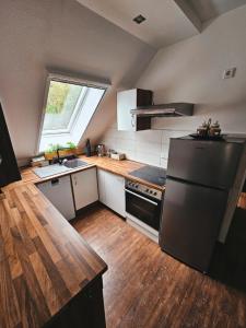 a kitchen with a black refrigerator and a wooden floor at Ferienwohnungen & Landlust Fulda in Petersberg