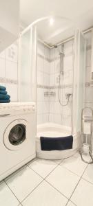 a washing machine in a bathroom with a shower at Apartament Opawska in Racibórz
