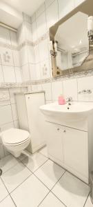 a white bathroom with a toilet and a sink at Apartament Opawska in Racibórz