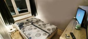 a small room with a bed and a desk with a computer at Apartament Opawska in Racibórz