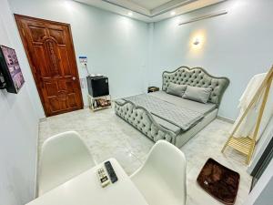 a room with a bed and a table and chairs at River 6 Hotel in Long Xuyên