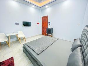 a bedroom with a bed and a couch and a table at River 6 Hotel in Long Xuyên