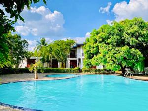 a large swimming pool in front of a house at Hotel Sanda Diya - Dambulla in Dambulla