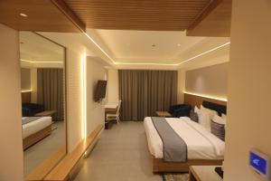 a hotel room with a bed and a television at Sapphire Blue in Bhopal +13 photos