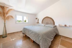 a white bedroom with a bed and a window at Maison de campagne 6 personnes in Saint-Julien