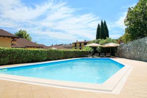 a swimming pool in a yard next to a fence at AHG Donna Silvia Wellness Hotel in Manerba del Garda
