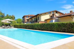 a swimming pool in front of a house at AHG Donna Silvia Wellness Hotel in Manerba del Garda