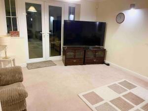 a living room with a large flat screen tv at Luxurious Executive 5 Bedroom Whole Home - For 10 in Hensol +20 photos