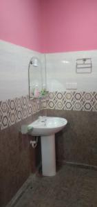 a bathroom with a white sink and a pink wall at Trinco White Villa in Trincomalee